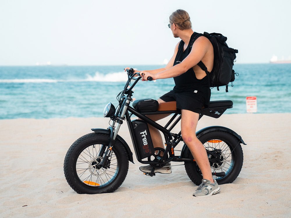 Rider with a backpack on a Freego Shotgun Prime F2 Pro by the sea