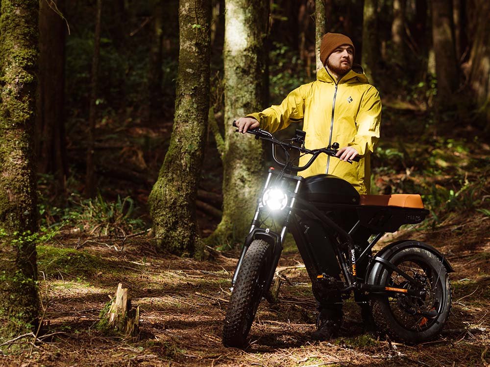 Rider on a Freego Flash F3 Pro Max on a forest track with the headlight on