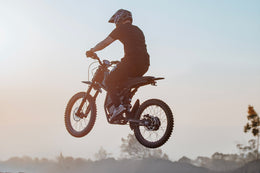 Riding'times GT73 mid-jump on a dirt track at dusk