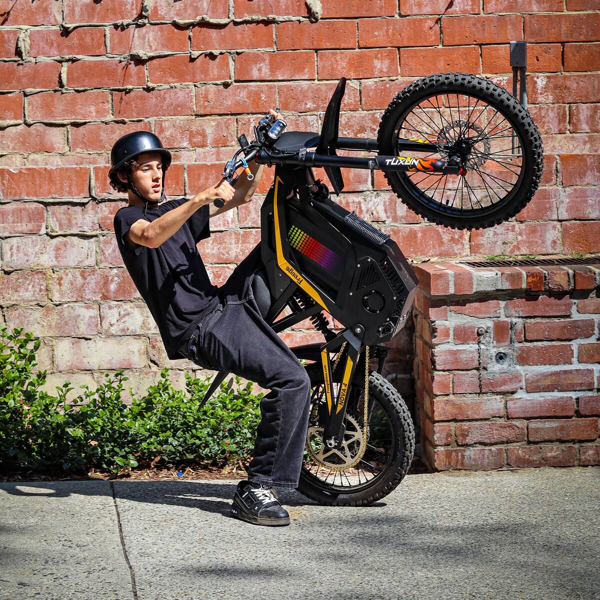 Freego Nova 4 ridden on the back wheel beside a brick wall