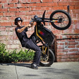 Freego Nova 4 ridden on the back wheel beside a brick wall