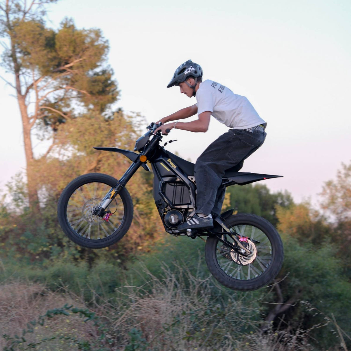 Freego Nova 5 airborne over a wooded jump