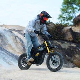 Rider in a full-face helmet riding a Nova 5 Mini down a rock slope