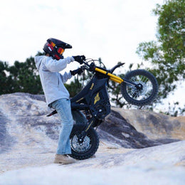 Rider in a full-face helmet lifting the front wheel of a Nova 5 Mini