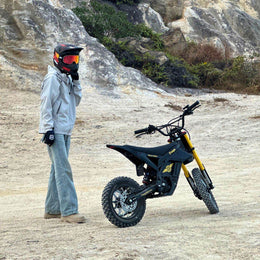 Rider standing beside a Freego Nova 5 Mini on a rocky trail
