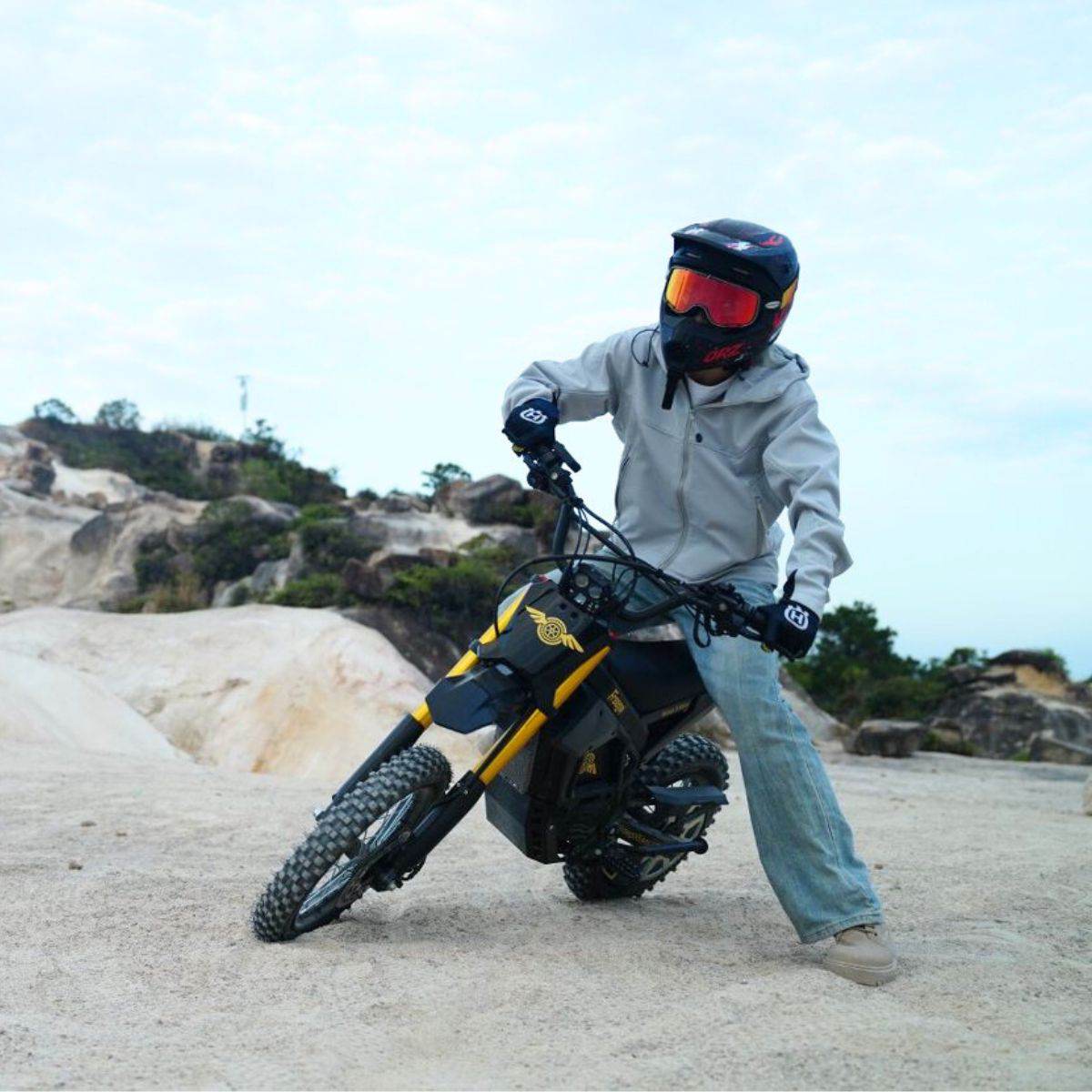 Rider in a full-face helmet on a Nova 5 Mini on rocky ground