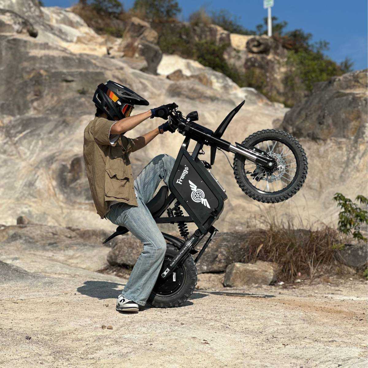 Rider in a full-face helmet on a Freego X0 on a rock face
