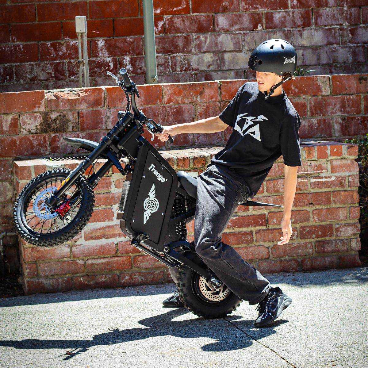Rider in a helmet on a Freego X0 beside a brick wall