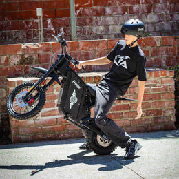 Rider in a helmet on a Freego X0 beside a brick wall