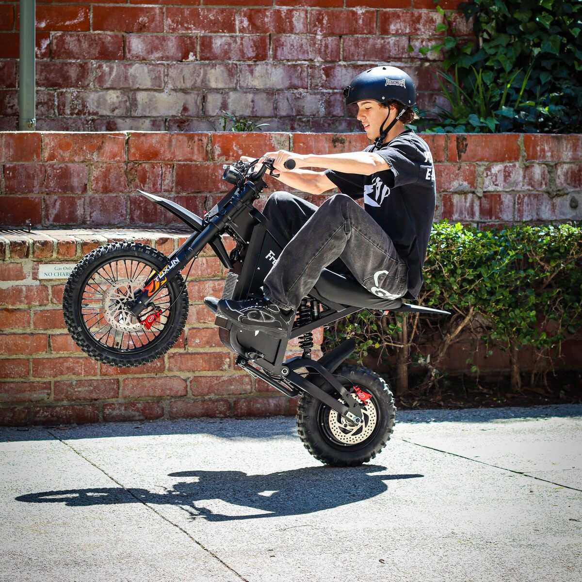 Rider in a helmet lifting the front wheel of a Freego X0