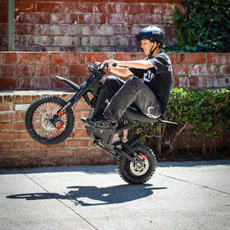 Rider in a helmet lifting the front wheel of a Freego X0