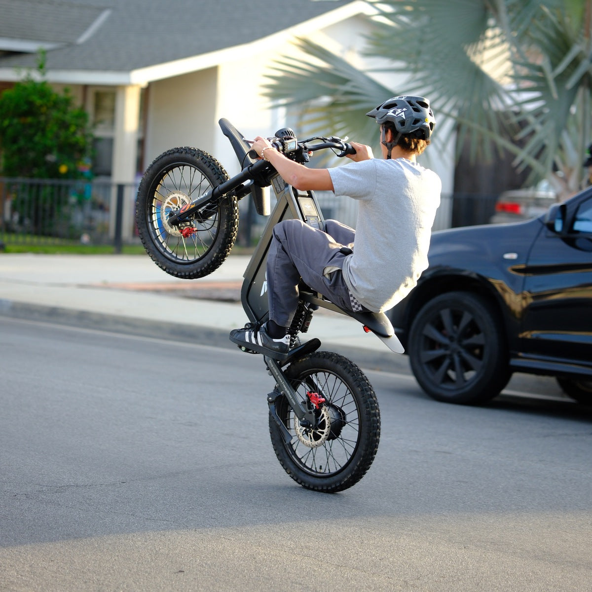 Rider in a helmet on a Freego X1 with the front wheel up