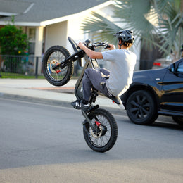 Rider in a helmet on a Freego X1 with the front wheel up