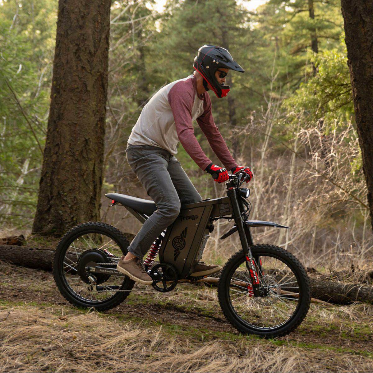 Rider in a helmet on a Freego X2 Pro riding over a fallen log