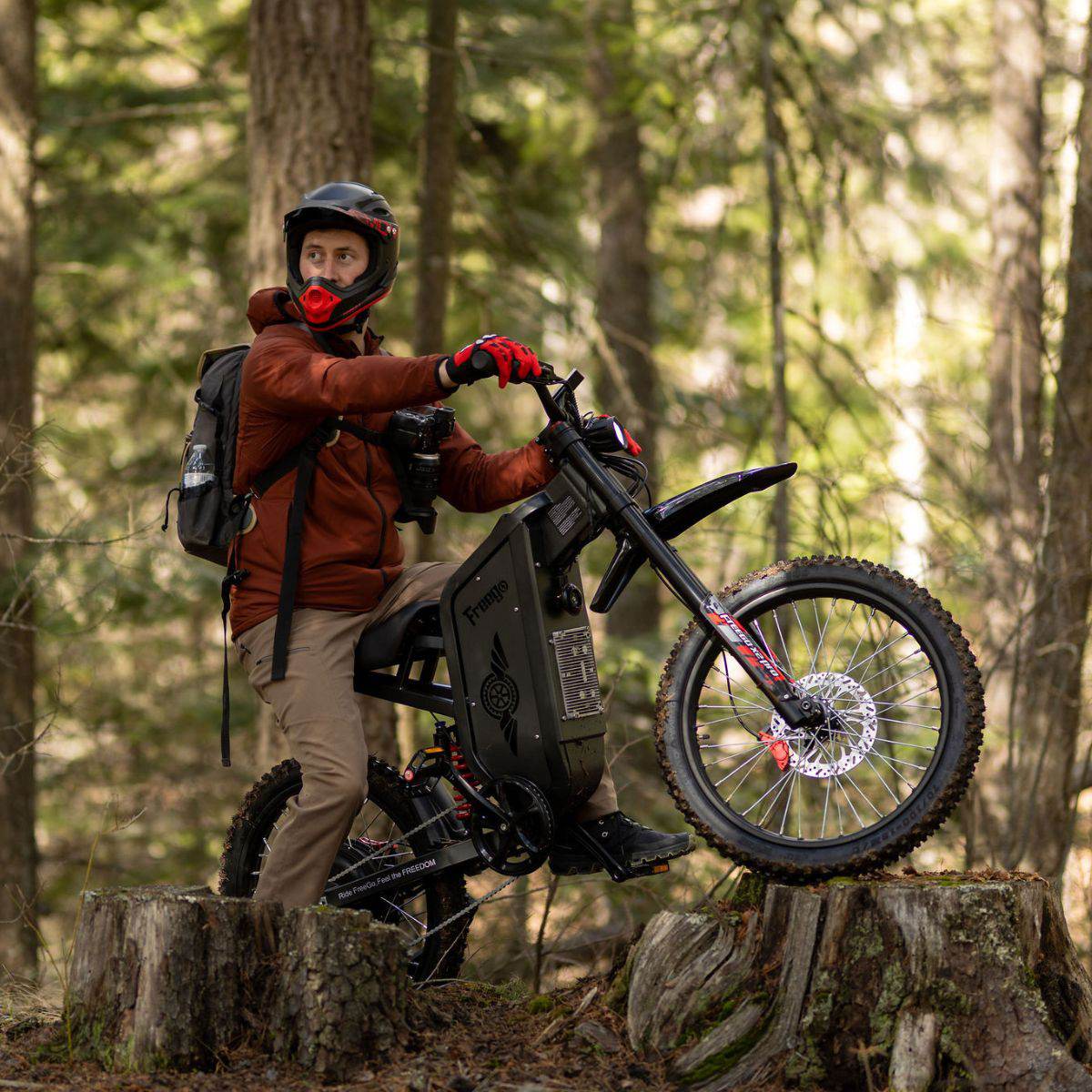 Rider in a full-face helmet lifting the front wheel of a Freego X2 Pro