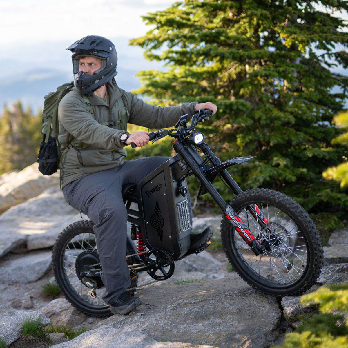 Rider in a full-face helmet on a Freego X2 Pro on a rocky outcrop