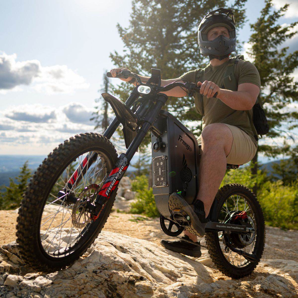 Rider in a helmet riding a Freego X2 Pro over rocks