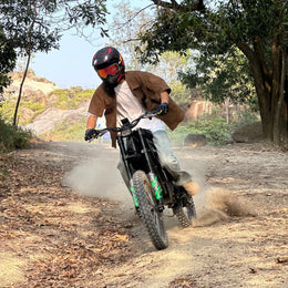 Rider in a full-face helmet on a Freego X3 Pro kicking up dust